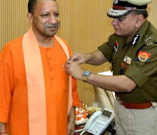 DGP Chauhan put flag pin on Yogi on Flag Day